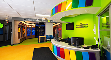 Interior view of the reception desk at the Zone with rainbow colored acrylic standoffs and lime green painted walls